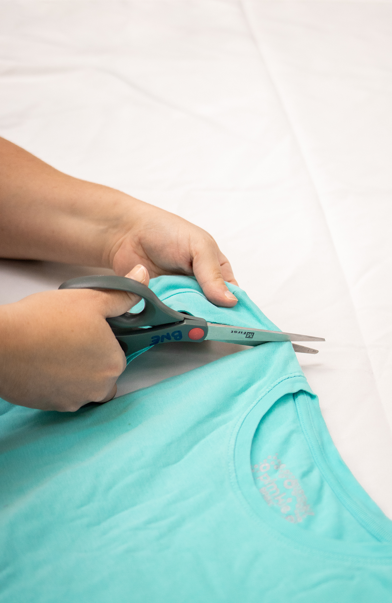 1&2. Mettre le t-shirt à plat sur une table et découper le col, les épaules et les manches.