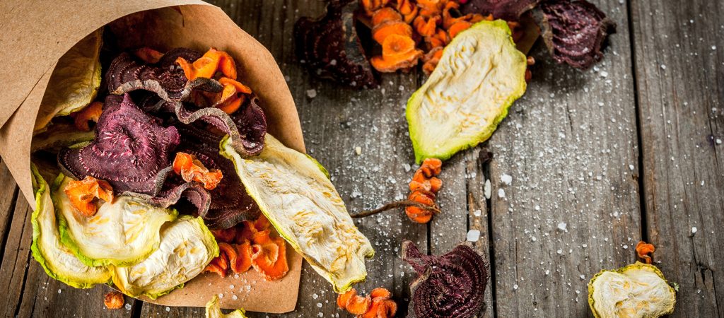 Organic diet food. The vegan diet. Dried vegetables. Homemade chips from beets, carrots and zucchini. On old wooden rustic table, with fresh vegetables. Copy space